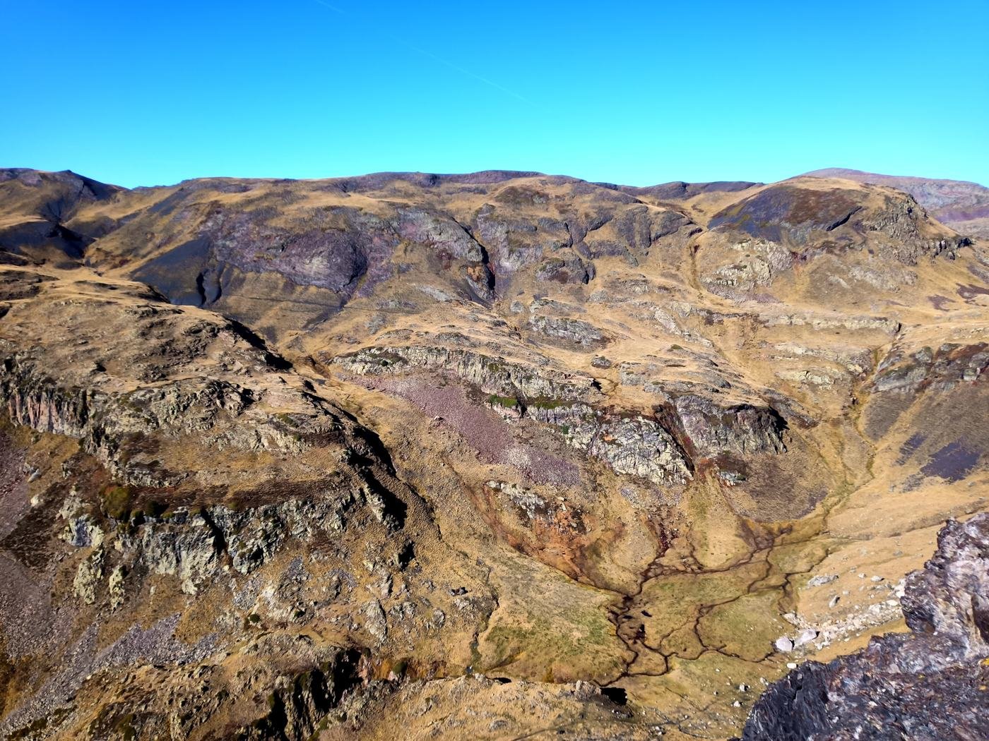 Vallon d'altitude aux reliefs ciselés, parcouru de ruisseaux, vu depuis une crête
