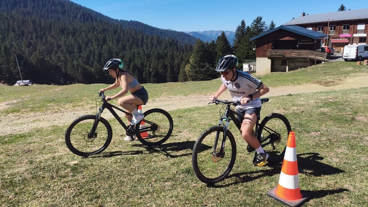 Deux participants en VTT sur le parcours d'un défi, au milieu des sapins