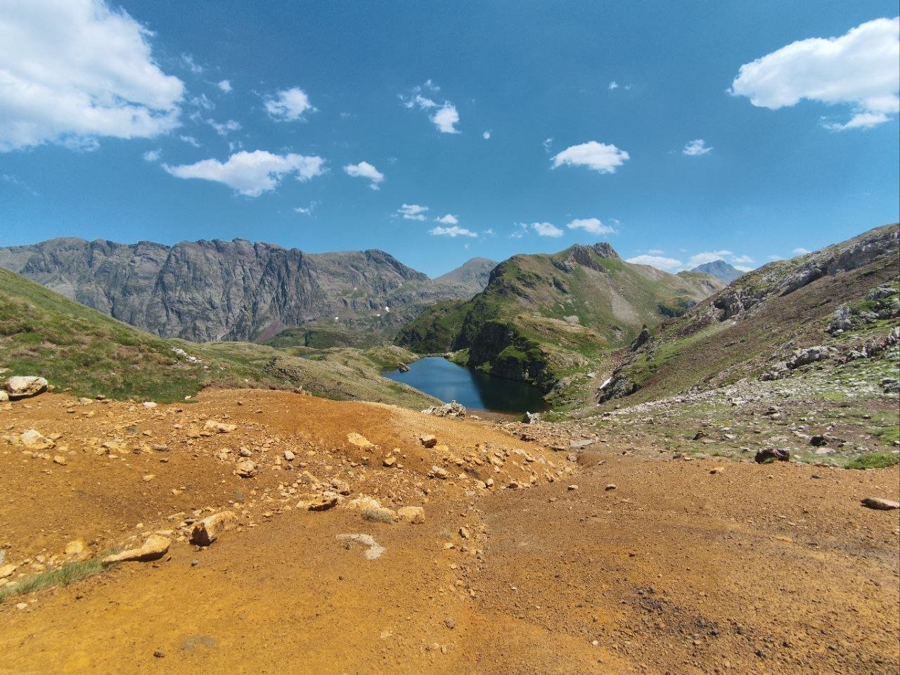 Terre ocre d'une ancienne mine au-dessus d'un lac d'altitude, dans le Val d'Aran